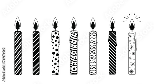A collection of black and white birthday candles with various patterns, one candle lit with starburst effect.