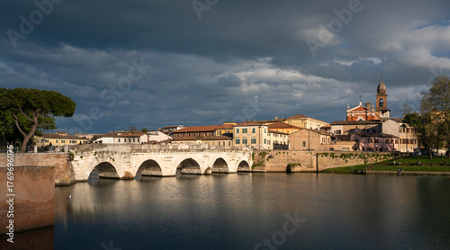 Rimini, italian travel destination. Tiberio bridge, roman architecture. Historic center at sunset.