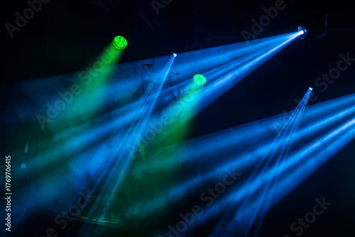Green and blue light beams on dark background