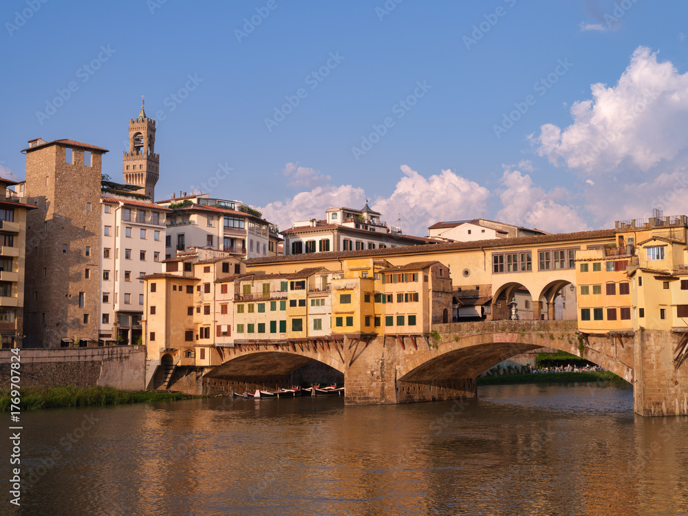 Naklejka premium Riverside Scene Florence Italy Historic Arched Bridge Italian Charm Culture