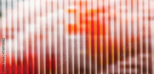 Light background with vertical white stripes and a blurred abstract shape in vibrant orange and red, suggesting warmth and energy