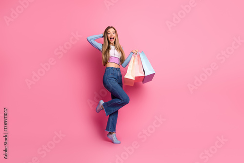Ταπετσαρία Young woman happily posing with shopping bags against a bright pink background w