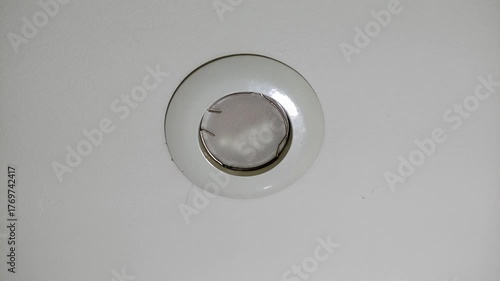 Broken, burnt out LED light bulb flickering on the ceiling