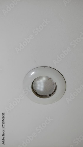 Broken, burnt out LED light bulb flickering on the ceiling