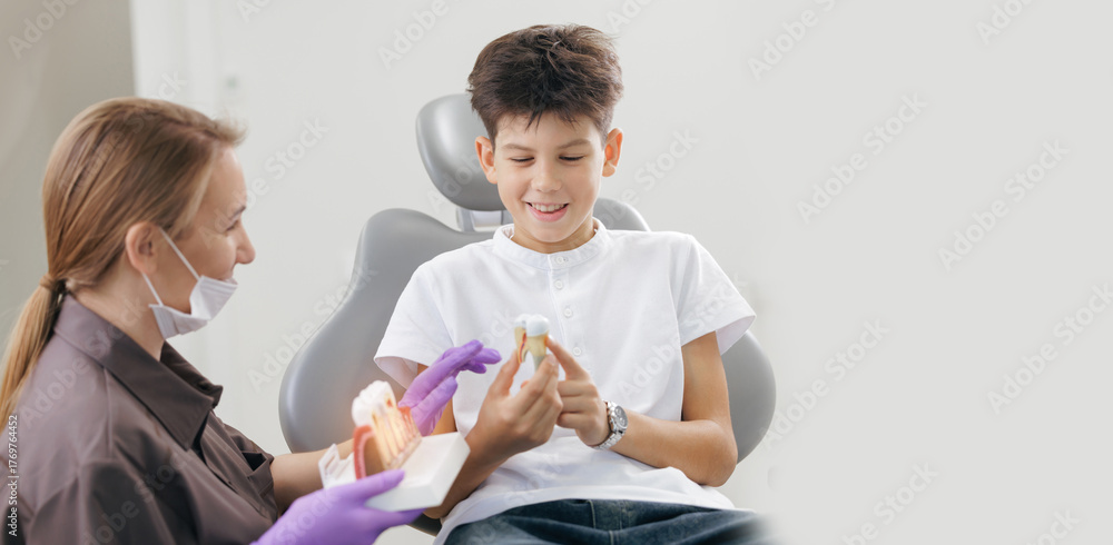 Obraz premium Asian female dentist educates young caucasian male patient on dental health