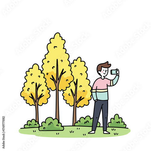 Young man taking selfie in park surrounded by yellow trees  