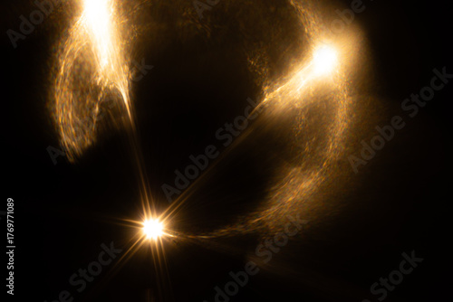Lens Flare. Light over black background. Easy to add overlay or screen filter over photos. Abstract sun burst with digital lens flare background. Gleams rounded and hexagonal shapes, rainbow halo.