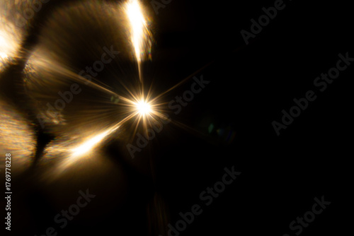Lens Flare. Light over black background. Easy to add overlay or screen filter over photos. Abstract sun burst with digital lens flare background. Gleams rounded and hexagonal shapes, rainbow halo.