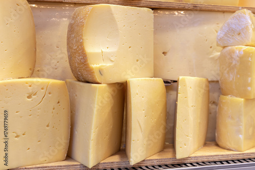 Aged hard cheese pieces displayed for sale in a market.