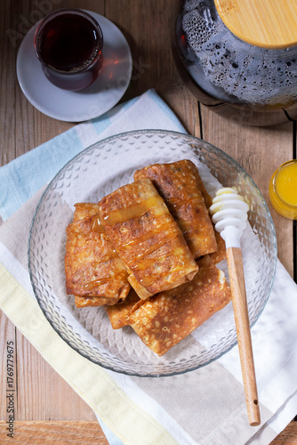 Pancakes with cottage cheese and raisin filling, served with honey and black tea. Traditional treat for Maslenitsa or Carnival.
