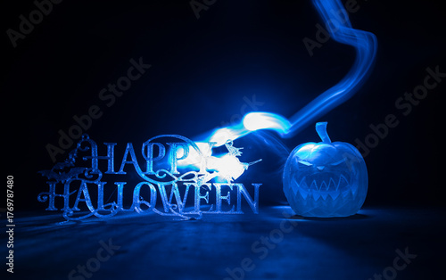 Halloween concept. Creepy silhouette in the dark corridor with pumpkin head. Toned light with fog on background.