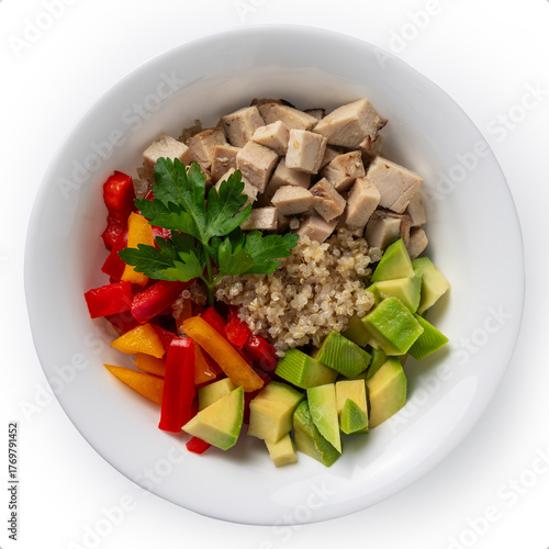 Top view of a nutritious quinoa bowl with grilled chicken, fresh avocado, bell peppers, and parsley on a clean white plate