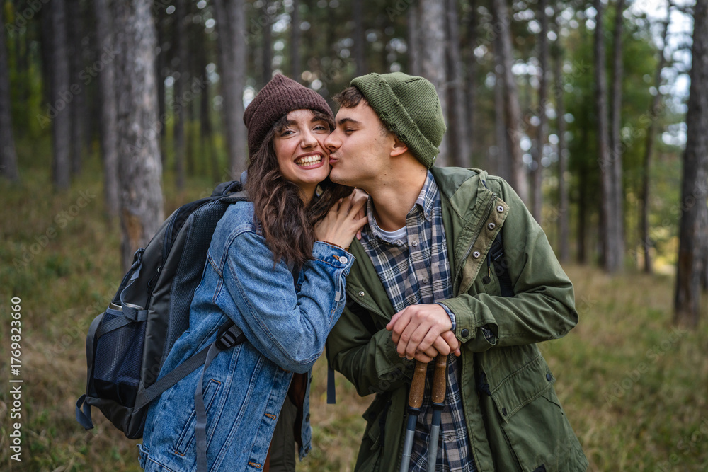 Fototapeta premium Young couple hiking in forest enjoying nature together