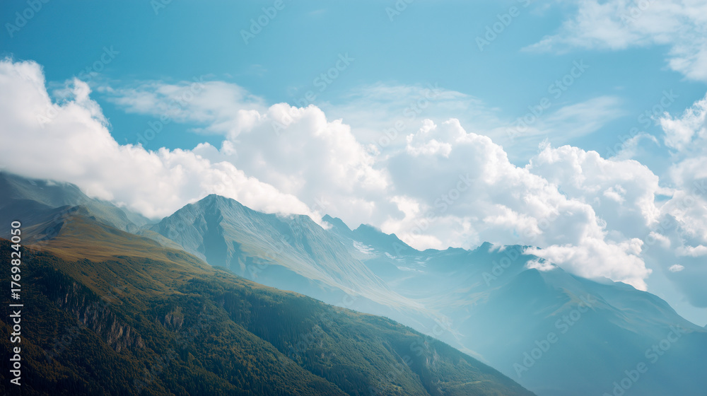 Fototapeta premium Scenic mountain landscape with rolling green hills under a bright blue sky and fluffy clouds