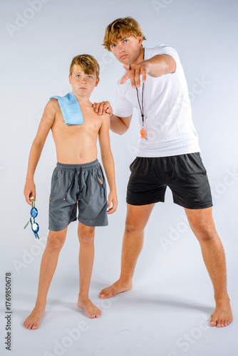 Swim coach giving instructions to a young swimmer before an important swimming competition