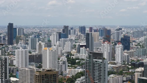 Vertical structures dominate cityscape, blend of contemporary architecture and traditional forms. Modern buildings with sharp edges and glass fronts stand alongside older designs with classic shapes