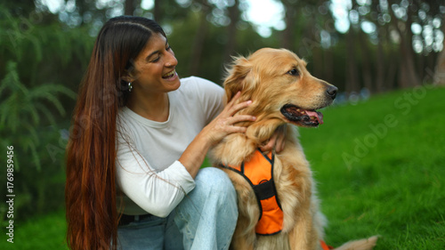 Woman petting golden retriever dog in park enjoying companionship