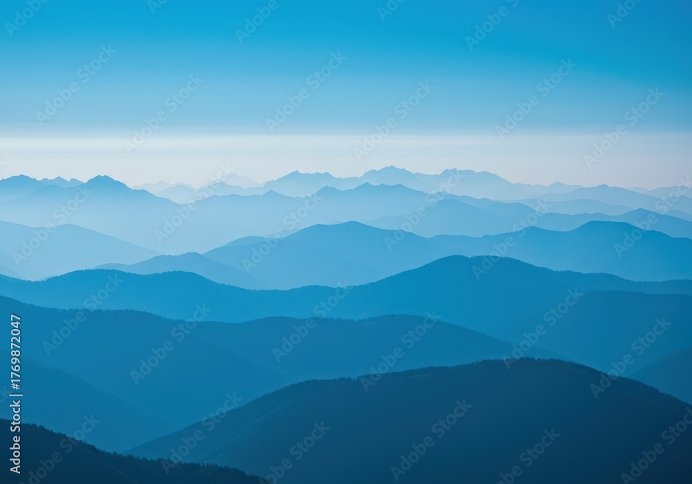 Obraz premium Scenic mountain range featuring hazy blue peaks stretching toward the horizon beneath a brilliant, cloudless sky ,daylight ,environment ,geography