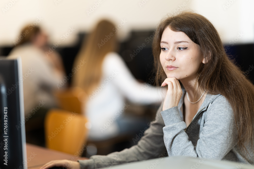 Obraz premium Portrait of young female student studying in university computer class