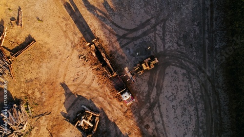 Construction site with heavy machinery in action during sunset hours creating new building foundations