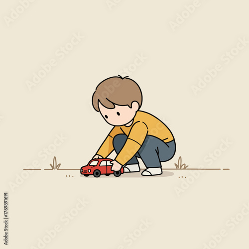 Young boy playing with a red toy car on the ground.