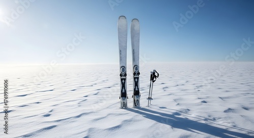 Pair of minimal skis resting upright in snow with blue sky background
