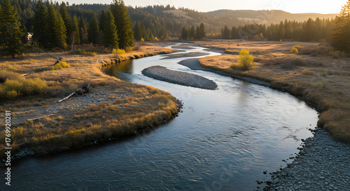 Serene river winding through a picturesque landscape under the golden sunlight.