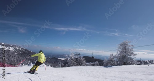 Snow-covered slopes invite a skilled skier to glide smoothly down the mountain in bright winter sun on a clear day