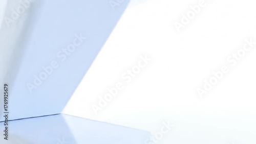 Abstract geometric shapes in a bright white space with soft lighting.