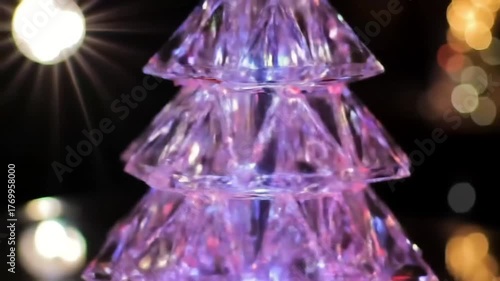 Illuminated crystal christmas tree decoration glowing with festive holiday lights