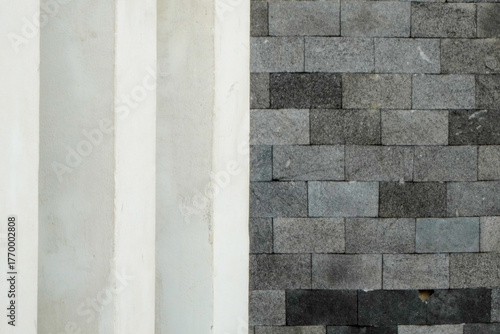 Close-up view of a wall with a contrast of white and gray brick textures.