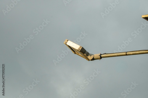 Streetlight against a cloudy sky, close-up view.