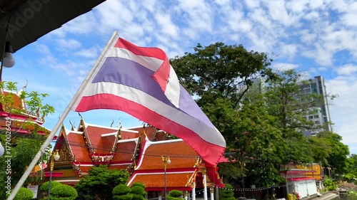Thai flag in the wind with the temple as the backdrop. The national flag of Thailand
