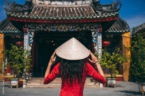 Wallpaper Mural A woman in a traditional Vietnamese dress on the background of the temple of Asian culture in Hoi An Torontodigital.ca