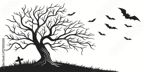 Silhouette of a bare tree with bats flying around and a tombstone on a grassy hill at halloween time