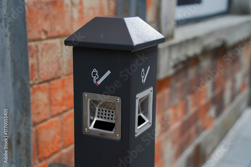 Modern street ashtray with built in hole in metal post, conditions for smokers, not to litter with cigarette butts public place. Outdoor smoking area zone
