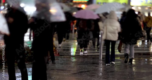 Walking people at business town in Shinjuku snowy day handheld at night