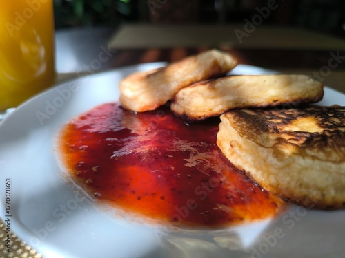 Pancakes on a plate with raspberry jam. Morning breakfast concept.