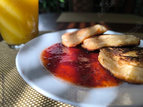 Pancakes on a plate with raspberry jam. Morning breakfast concept.