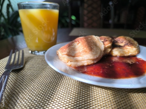 Pancakes on a plate with raspberry jam. Morning breakfast concept.