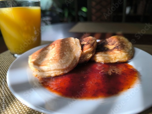Pancakes on a plate with raspberry jam. Morning breakfast concept.