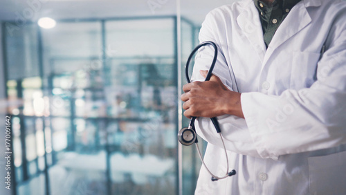 Stethoscope, hands or doctor with arms crossed in clinic, healthcare professional or cardiology career. Medical specialist, space or confident man with health support, cardiac care and heart wellness