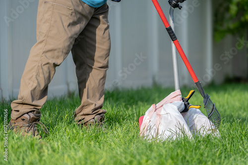 Foto Pooper scooper scooping in grass