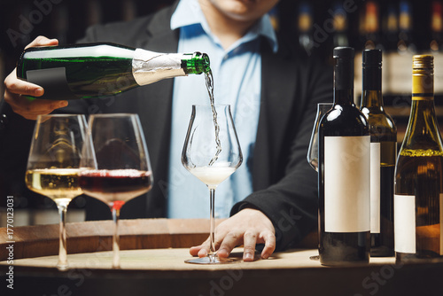 Sommelier Pouring Champagne into Glass in Cellar