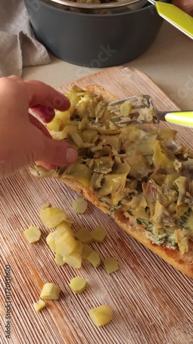 Anonymous person cook boiled artichoke bruschetta. Healthy eating and traditional Italian dish. Farm-fresh seasonal produce.