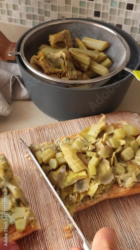 Anonymous person cook boiled artichoke bruschetta. Healthy eating and traditional Italian dish. Farm-fresh seasonal produce.