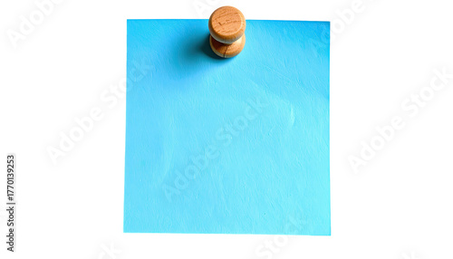 Blue paper note pinned by wooden tack to blank dark backdrop