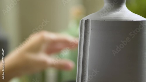 Woman ceramist fully absorbed in decorating her pottery creation. The joy of hands-on artistic craftsmanship.