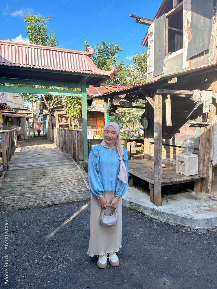 Φωτογραφία A woman in a pastel outfit cheerfully poses in a quaint village with traditional