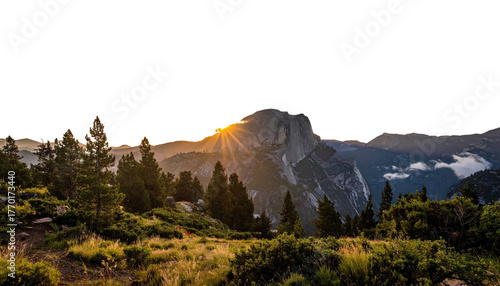 Mountain peak sunset behind trees on hill. Golden sun rays
